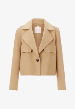 Giacca corta beige realizzata in tessuto morbido, con colletto a pistagna, due tasche frontali e chiusura con un singolo bottone marrone.