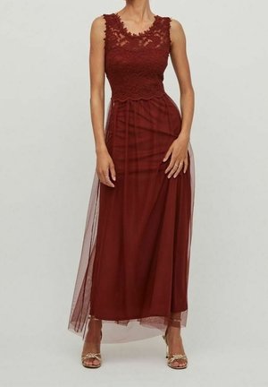 Bezramkowa bordowa koronkowa sukienka z przezroczystą tiulową nakładką sięgającą kostek, w połączeniu ze złotymi butami na obcasie z odkrytymi palcami.