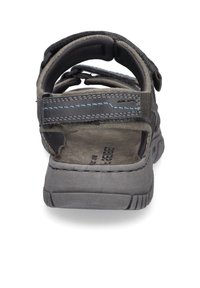 Szare sandały na zewnątrz z regulowanymi paskami, teksturowaną gumową podeszwą i niebieskimi akcentami wyszycia. Posiadają otwarte pięty i wyściółkę na stopie.