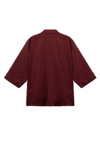 Giacca in stile kimono color bordeaux con vestibilità comoda, maniche ampie e un tessuto leggermente texturizzato. Presenta un colletto e nessun sistema di chiusura.