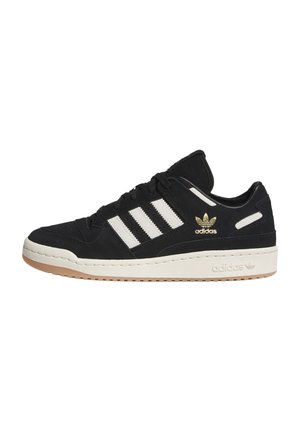 Sort Adidas-sneakers med hvide striber og sål, gyldent Adidas-logo og gummibelagt ydersål set fra siden.