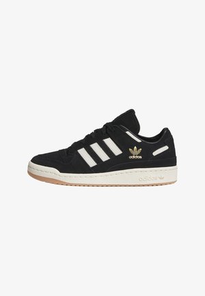 Czarny sneaker Adidas z białymi paskami i podeszwą, złotym logo Adidas oraz gumową podeszwą, widziany z boku.