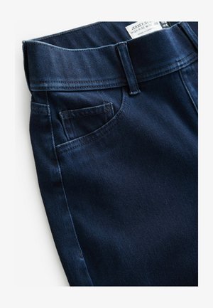 Tamne traperice visokog struka širokih nogavica u tamnoplavoj boji s ušitom gumicom u struku, bočnim džepovima i glatkom teksturom. Oznaka vidljiva na vrhu.