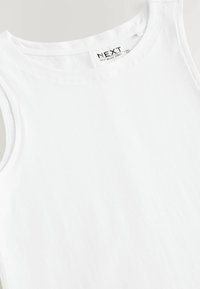 Valge tank top siledast puuvillast ümarate kaelustega ja ilma varrukateta disainiga. Sildil on kirjas "NEXT" ja riideüksuse üksikasjad.