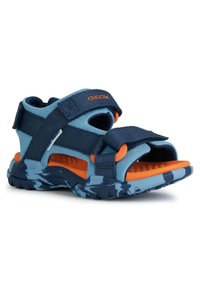 Modré a námořnické sandály s nastavitelnými popruhy, prodyšný vršek z mřížky, oranžové akcenty, texturovaná podrážka a vzorovaná modrý kamuflážní podrážka.