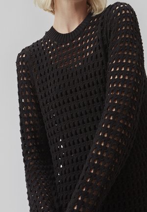 Pull en maille noire léger avec une texture en maille ouverte, col rond et manches longues, à coupe ample et détails à motifs.