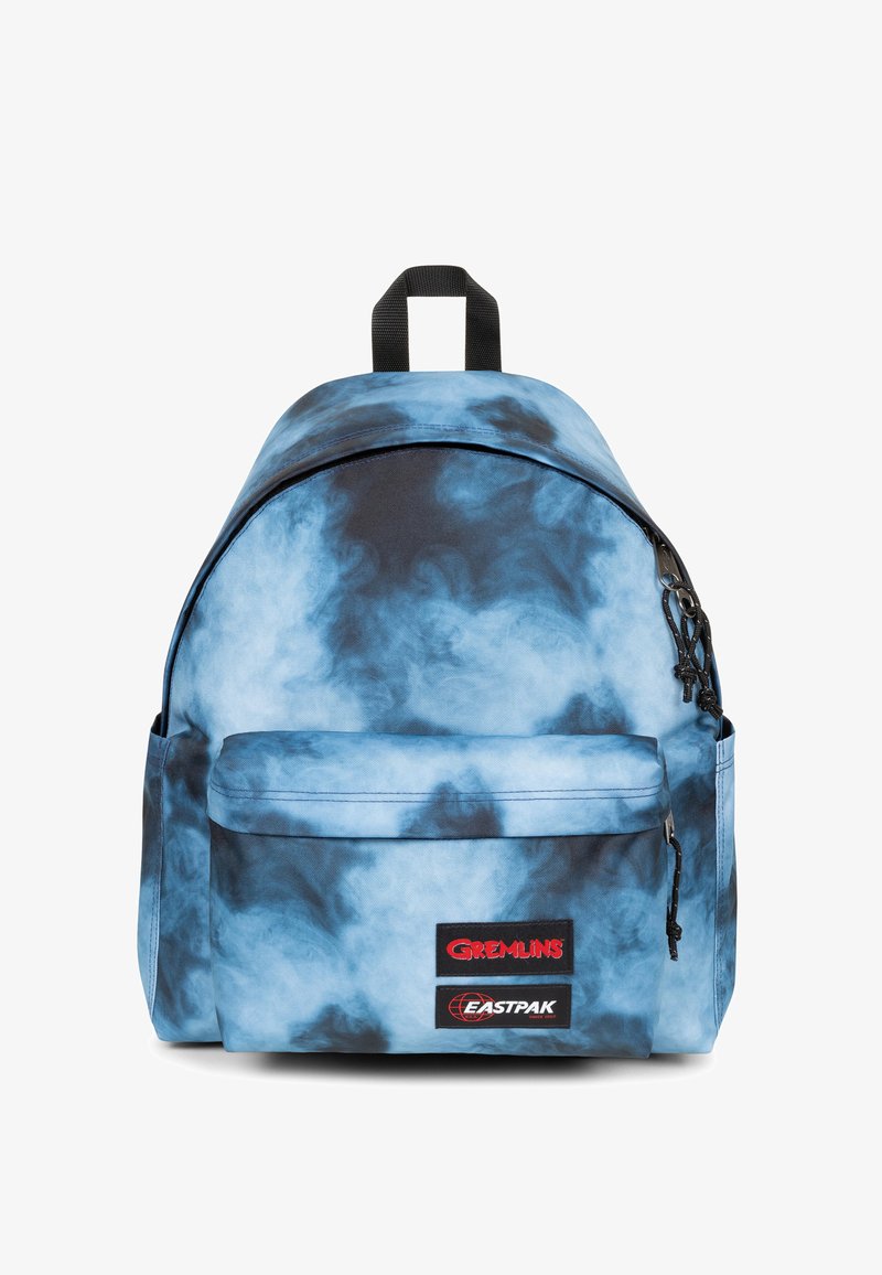 Zaino in tessuto tie-dye blu dalla forma arrotondata, con tasca frontale e accessori neri. Presenta i loghi: "GREMLINS" e "EASTPAK".