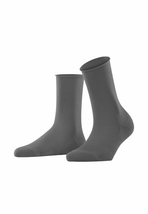 Chaussettes de sport grises fabriquées en un matériau doux et extensible. Elles possèdent un poignet côtelé et une texture lisse avec des orteils et talons renforcés.