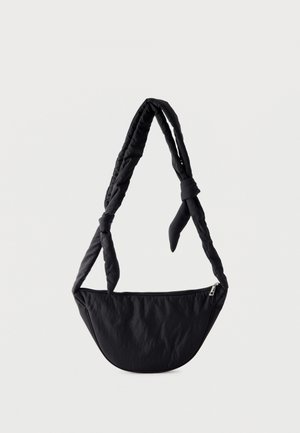 Geantă crossbody neagră căptușită, cu formă de semilună și curea reglabilă cu noduri, prevăzută cu închidere cu fermoar în partea superioară.