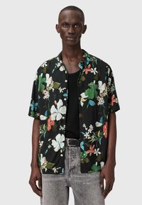 Czarna koszula z krótkim rękawem z żywym kwiatowym wzorem w kolorach zielonym, czerwonym, niebieskim i białym. Lekki materiał o luźnym kroju z guzikami.