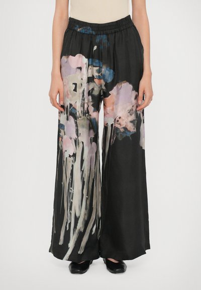 Black wide-leg trousers made of smooth fabric, featuring a colorful abstract print of pink and blue shapes. Elastic waistband design.