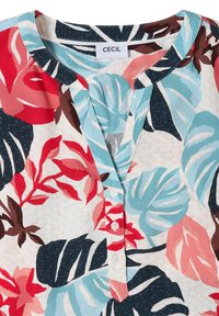 Chemise avec motif coloré de grandes feuilles tropicales en rouge, bleu, marron et noir, encolure ronde et trois boutons blancs à l'avant.