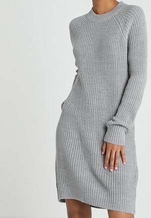 Robe pull en gris tricotée avec un motif texturé, des manches longues, un col rond et des fentes sur les côtés pour plus de liberté de mouvement.