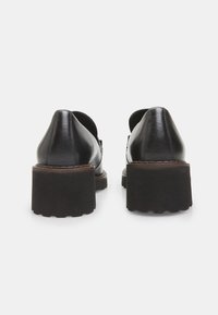 Chaussures en cuir noir avec un talon épais et un dos pointu. Finition lisse avec un détail de couture et une semelle en caoutchouc épaisse pour une bonne adhérence.