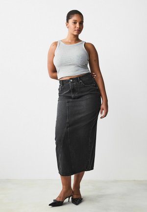 Black denim midi skirt with a straight cut, featuring front seams and a high waist. Paired with a fitted gray tank top and black heels.
