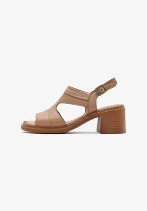 Tan leather heeled sandals with open toe, side cutouts, and adjustable ankle strap. Features a textured block heel.
