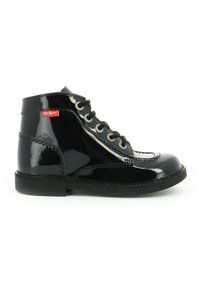 Bottines en cuir verni noir avec bout arrondi, lacets gris contrastants et logo Kickers rouge sur le côté. Semelle en caoutchouc plate.