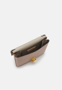 Structured handbag in light beige textured leather. Features a contrasting olive-green interior with a gold-tone clasp and flap closure.