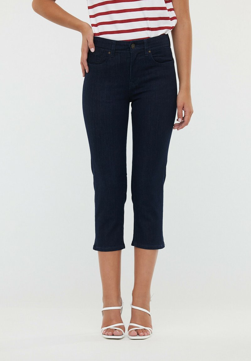 Jean cropped bleu marine au design ajusté, fabriqué en tissu en denim. Comprend quatre poches et une taille avec une fermeture à bouton.