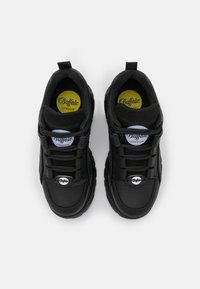 Svarta sneakers med en slät läderfinish, rund tå, platta snören och en vadderad insoles, med en cirkulär logotyp på sidan.