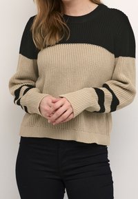 Pull en maille côtelée, avec des rayures horizontales noires et beiges et des manches longues. Encolure arrondie et ourlet ajusté.