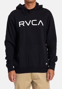Black hooded sweatshirt made of cotton blend, featuring a large white "RVCA" logo on the front and a front pouch pocket.