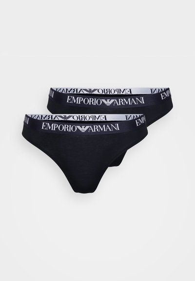 Czarne bawełniane stringi z białym pasem z logo "Emporio Armani", prezentowane w opakowaniu po dwa. Miękka tekstura oraz dopasowany fason.