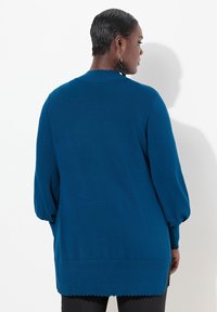 Maglione blu lavorato a maglia con maniche a palloncino lunghe, colletto scallop e orlo, con una vestibilità comoda e tessuto testurizzato.