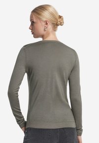 Langärmliger Pullover in olivgrün, aus weichem Material, figurbetontes Design, gerippte Bündchen und Saum, glatte Textur, minimalistischer Stil.