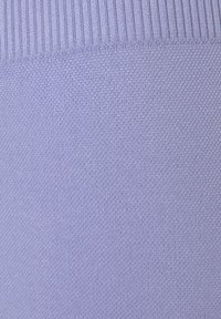 Lichtpaars gebreide stof met een gladde textuur, met een ribbelpatroon aan de bovenkant. Effen kleur en strak geweven door heel de stof.