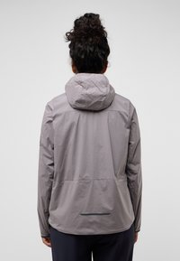 Lightweight gray jacket with a hood, featuring a smooth, matte texture and a reflective accent on the back. Designed for outdoor use.
