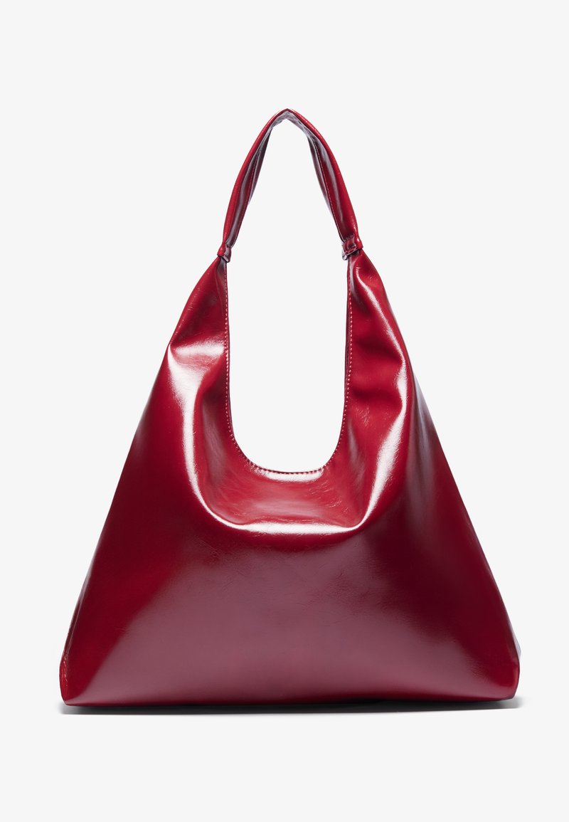 Sac à main en cuir laqué rouge de forme triangulaire, avec une large ouverture en haut et une seule anse courbée. Texture lisse avec des détails de couture minimaux.