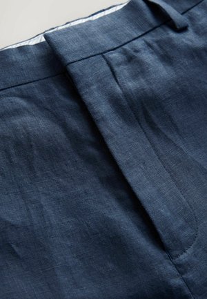 Diepblauwe linnenbroek met een gladde textuur, een op maat gemaakte tailleband en zijzakken met netjes gestikte naden.