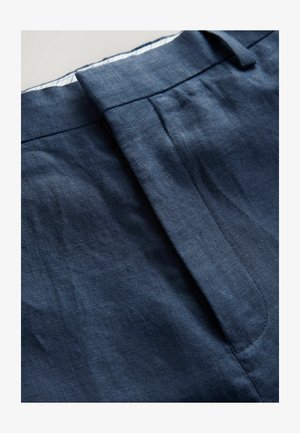 Sötétkék vászon nadrág, sima textúrával, elegáns derékpánttal és oldalzsebekkel, szépen varrt varrásokkal.