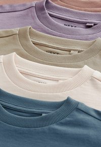 Cztery bluzy crewneck w różnych kolorach: lawendowym, beżowym, brzoskwiniowym i turkusowym. Bawełnowy materiał z prążkowanymi kołnierzami i casualowym fasonem.