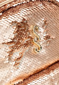 Borsa rivestita di paillettes rosa oro che presenta una texture liscia e una chiusura in metallo dorato lucido a forma di "S".