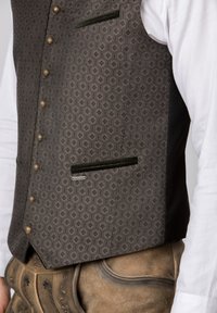 Grau gemusterte Weste mit goldenen Knöpfen, grünen Akzenten und zwei vorderen Taschen. Getragen über einem weißen Hemd und braunen traditionellen Hosen.