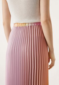 Gonna a pieghe in sfumature di rosa degradé, con una cinta in costina dai colori pastello. Tessuto liscio, simile al raso, con righe verticali.