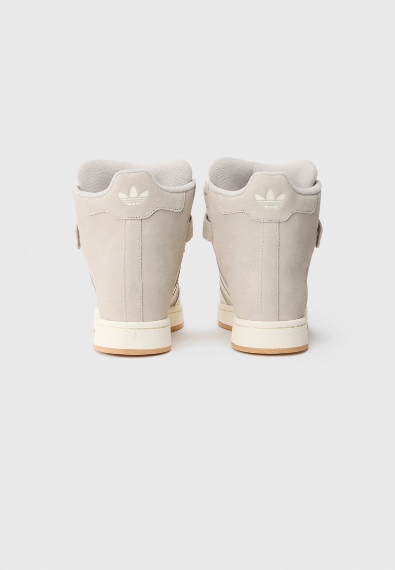 Sneakers alte in suede grigio chiaro, con suola bianca e dettagli logo discreti sul tallone e sul lato. Tessuto liscio e design snello.