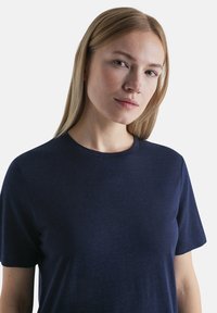 Navyblaues Kurzarm-T-Shirt aus weichem Stoff. Verfügt über einen runden Halsausschnitt und eine dezente Textur, mit lockerer Passform. Keine sichtbaren Logos.