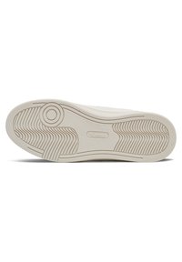 Weißer Sneaker-Sohle mit strukturierten Rutschmustern und einem kreisförmigen Emblem. Abgerundete Kanten und dezente Markenintegration im Design.