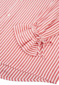 Czerwona i biała koszula w paski z zapięciem na guziki i detalem z bufkami na rękawach, z marszczoną tkaniną i wiązaniami. Miękki bawełniany materiał.