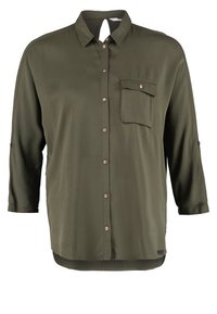 Chemise à manches longues vert olive à boutons, avec col et poche poitrine à rabat boutonné.