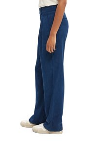 Navyblauwe corduroy wijde broek met verticale strepen, met een hoge taille en subtiele textuur. G gedragen met witte sneakers.