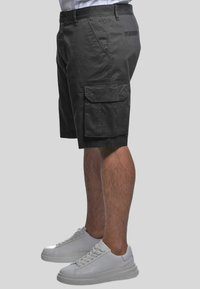 Pantaloni cargo neri con molte tasche, realizzati in tessuto misto cotone, caratterizzati da una vestibilità comoda e una texture liscia.