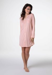 Camicia da notte rosa chiaro con bottoni, dotata di tasca sul petto, maniche lunghe e orlo arrotondato. Realizzata in tessuto morbido e leggero.