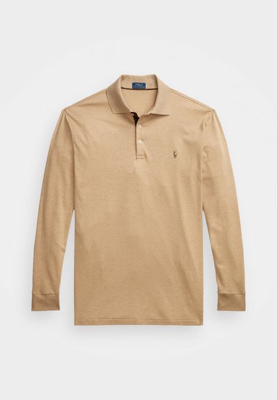 Bež majica s dugim rukavima polo kroja, izrađena od mekanog pamuka. Ima klasičan ovratnik, placket sa tri dugmeta i mali izvezeni logo na prsima.