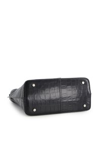 Black rectangular handbag with crocodile texture, four metal feet on bottom, shown lying on its side on a white background.