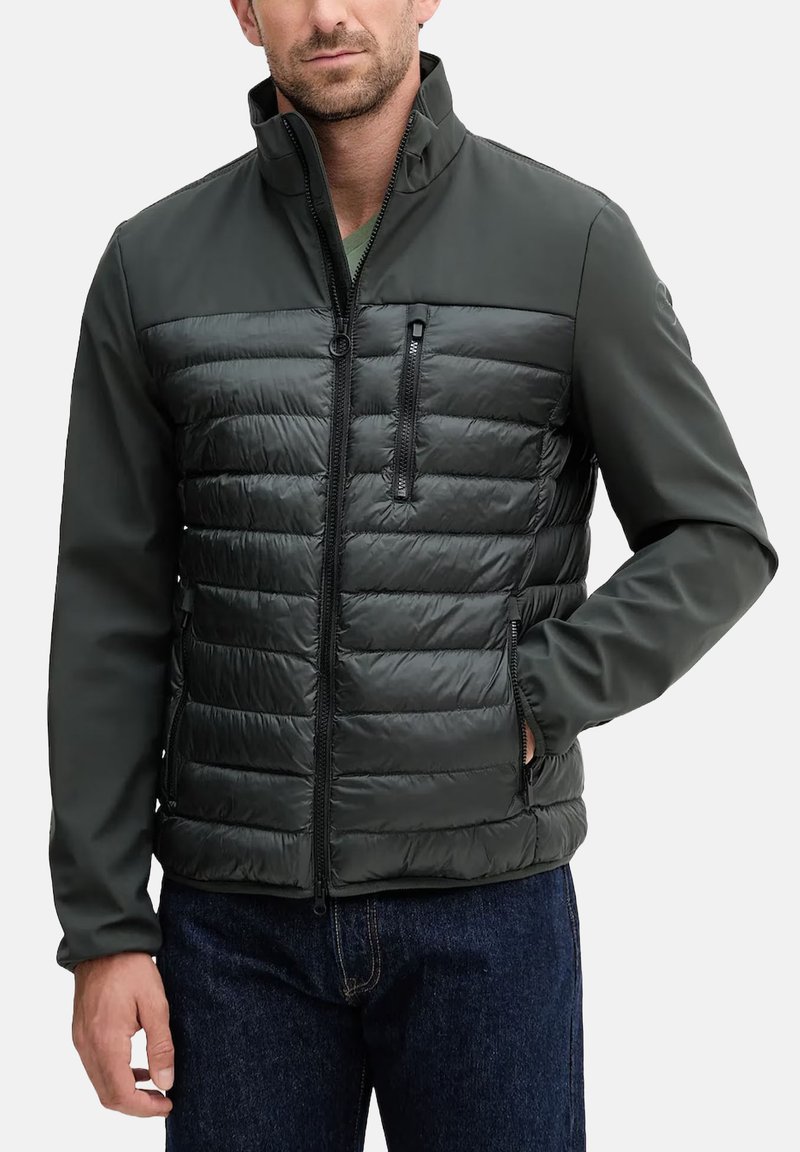 Giacca ibrida verde scuro con fronte trapuntato imbottito, maniche lisce, tasche con cerniera, collo alto e vestibilità sagomata.