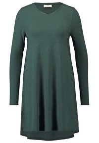 Zielona sukienka z długim rękawem i dekoltem w kształcie litery V, wykonana z miękkiego materiału. Posiada luźny fason i nieco dłuższy tylny brzeg.